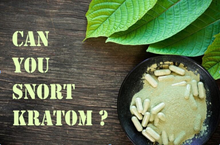 A bowl of kratom powder lying next to kratom leaves; the caption reads, "Can you snort kratom?”